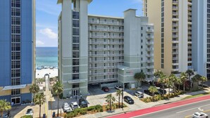 Un hôtel à plusieurs étages doté d’une cour intérieure, d’un parking et offrant une vue sur la plage.