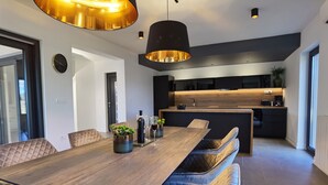 A modern kitchen with a wooden countertop, a built-in oven, and a black backsplash. - Stylish Designer Villa with Pool & Guest Apartment Near the Sea (Nedescina)