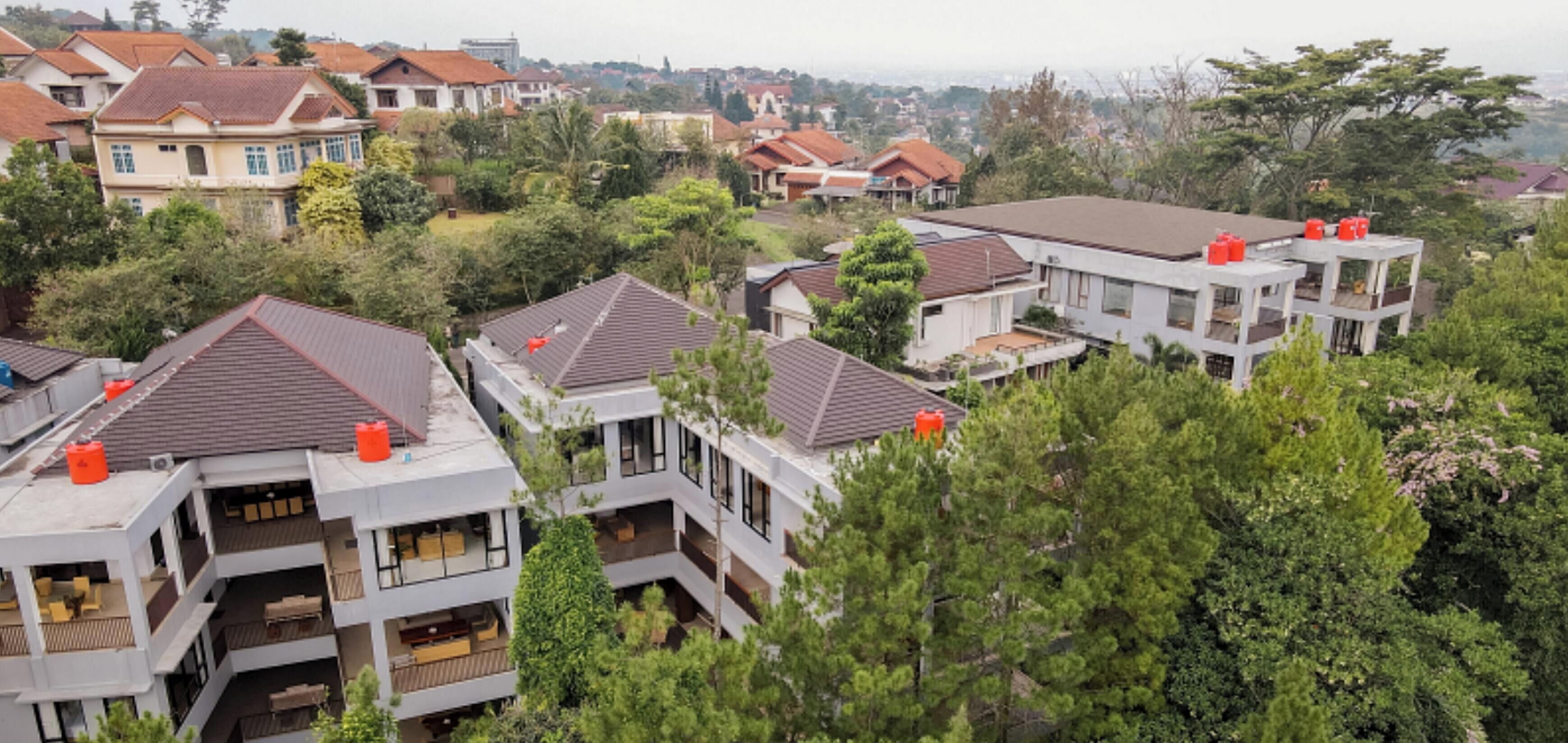 Un barrio residencial con casas modernas, balcones y techos de tejas rojas.