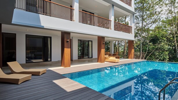 A modern two-story building with a swimming pool, outdoor seating, and a balcony with wooden railings. - Atsuka Hill View 8BR Vila with Private Heated Pool (Cimenyan)