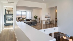 A spacious living area with a balcony, a kitchen, and a dining area. - Golden Hour: Desert Color Lagoon + Beaches (St. George)