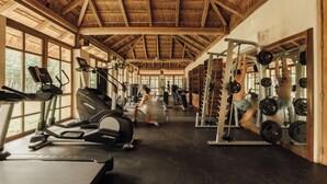 A gym with treadmills, weight machines, and a mirrored wall. - Lumina at LOSANTOS Tulum (Tulum)