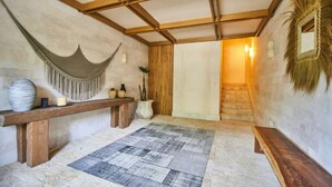 A room with a wooden bench, a woven hanging chair, a patterned rug, and a staircase leading to another area. - Lumina at LOSANTOS Tulum (Tulum)