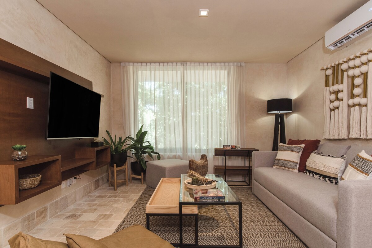 A modern living room with a flat-screen TV, a sofa, a coffee table, and a TV stand.