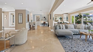 A spacious living room with a large gray sofa, a coffee table, and a patterned rug. - Heated Pool Waterfront Retreat – A Fun, Sun-Soaked Florida Getaway on the Waterway Escape Now! (Fort Lauderdale)