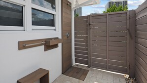 A gated entrance with a wooden door and a metal handle, a small wooden bench, and a tiled patio area. - Heated Pool Waterfront Retreat – A Fun, Sun-Soaked Florida Getaway on the Waterway Escape Now! (Fort Lauderdale)