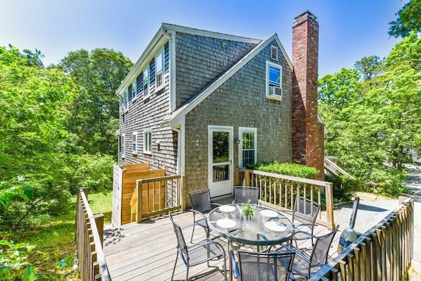 A house with a deck, a brick chimney, and a window with a view.