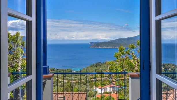 Ein Balkon mit Blick auf das Meer und die entfernten Hügel.