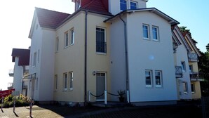 A multi-story building with a red roof, beige walls, and multiple windows. - Clason vacation apartment with sea view (Heringsdorf)