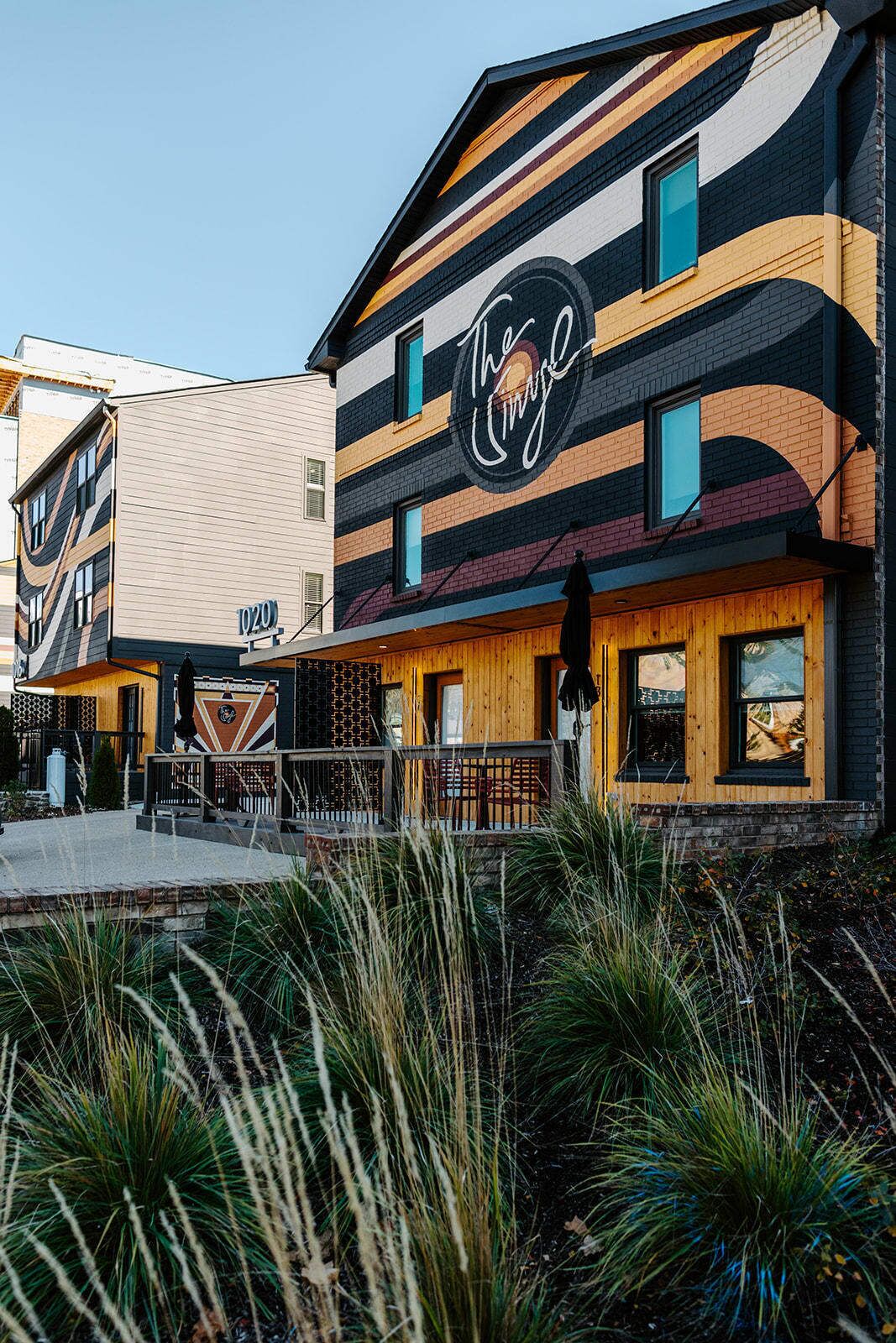 A building with a striped facade, a prominent sign with a logo, and a number '020' on the side.