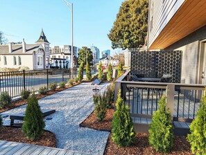 A residential area with a paved driveway, small trees, and a wooden deck. - Songwriter's Suite: Luxe Music Row Stay! (Nashville)