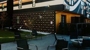 A modern building with a unique facade, outdoor seating area with chairs and a fire pit, and a sign indicating the year 2016. - Songwriter's Suite: Luxe Music Row Stay! (Nashville)