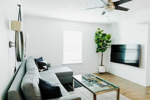 Una sala de estar moderna con un sofá, una mesa de centro y un televisor.