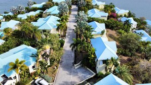Un resort con varias edificaciones, un camino central y palmeras circundantes.