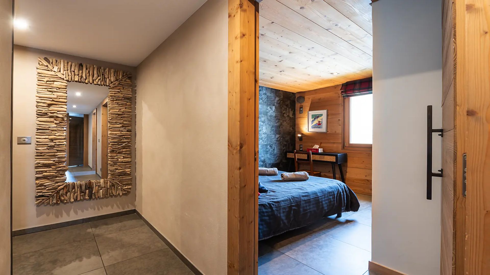 Ein Schlafzimmer mit einer Steinsäule, einem Bett, einem Schreibtisch und einem Fenster.