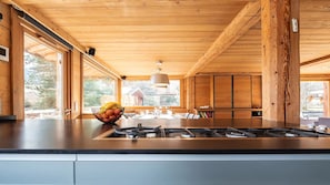 A modern kitchen with a large island, wooden ceiling, and large windows. - Chalet Alpen, 5 bedrooms, sauna, near Megève and the ski slopes. (Praz-sur-Arly)