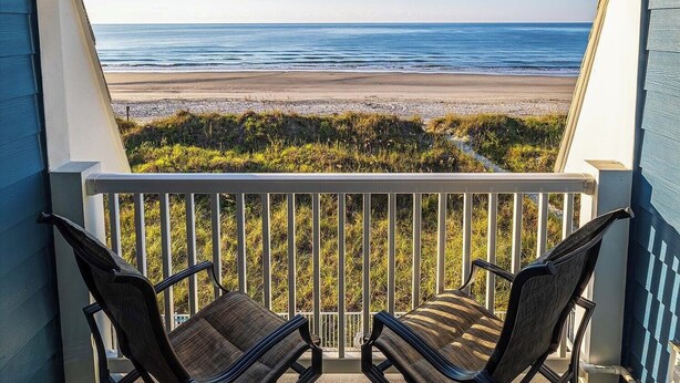 A balcony with two chairs facing a beach view. - Recently renovated condo in Cherry Grove area of N. Myrtle Beach (North Myrtle Beach)
