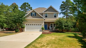 A two-story house with a garage, a front lawn, and a driveway.