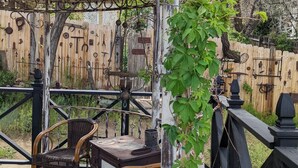 Una terraza de madera con mobiliario de mimbre y una estufa antigua que dice "SUNSET".