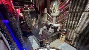 A luxurious bathroom with a large bathtub, a vanity with a mirror, and a decorative plant. - Priamos Hotel Erato (Athens)