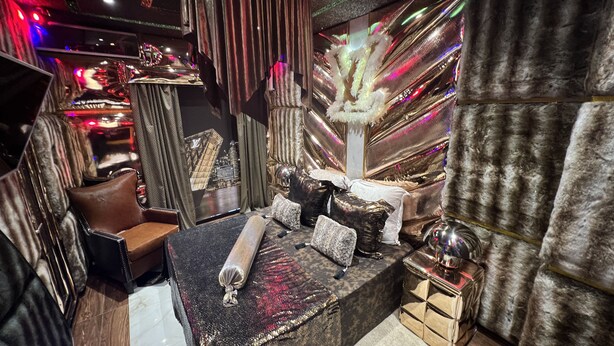 A luxurious interior with a plush seating area, a decorative mirror, and a chandelier. - Priamos Hotel Erato (Athens)