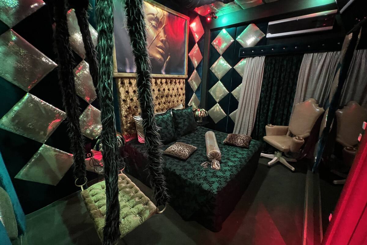 A modern room with a green sofa, a chair, and a decorative wall with diamond patterns.