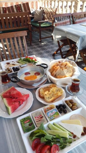 Une table dressée avec une variété d’aliments, notamment du pain, des œufs, des olives et des tomates, ce qui laisse supposer qu’il s’agit d’un petit-déjeuner ou d’un brunch.
