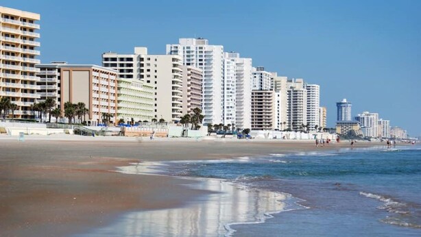 A beachfront hotel with multiple high-rise buildings, a sandy beach, and ocean waves. - Beachside Daytona Beach Shores 5 min walk to beach, restaurants and more! (Port Orange)