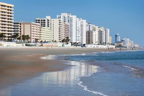 A beachfront hotel with multiple high-rise buildings, a sandy beach, and ocean waves. - Beachside Daytona Beach Shores 5 min walk to beach, restaurants and more! (Port Orange)