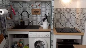 A compact kitchen with a washing machine, a sink, and a stove. - Comfortable air-conditioned studio in a quiet villa 15 km from Cannes (Peymeinade)
