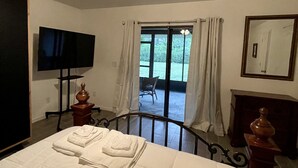 A hotel room with a bed, a ceiling fan, a TV, a window with curtains, and a view of the outdoors. - 🏝Beaches, Nature Sanctuaries, and Rockets with plenty of room for a family. (Palm Bay)