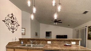 A kitchen with a central island, stainless steel dishwasher, and a ceiling fan. - 🏝Beaches, Nature Sanctuaries, and Rockets with plenty of room for a family. (Palm Bay)