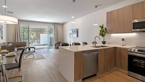 Una cocina moderna con una isla central, horno empotrado y electrodomésticos de acero inoxidable.