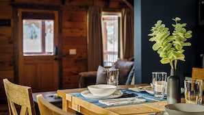 Ein Holztisch mit einer Vase mit Grünpflanzen, klaren Gläsern und Schalen.