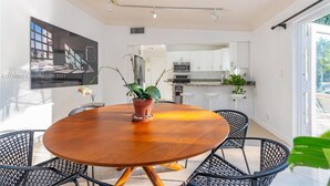 Una cocina moderna con armarios blancos, un refrigerador de acero inoxidable y un microondas.