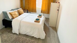 A bedroom with a bed, a dresser, a nightstand, and a window with curtains. - Specious roofapartment apartment, tropical velvet (Helsinki)