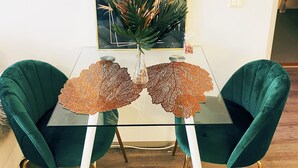 A dining table with two chairs, a vase with a plant, and a framed picture on the wall. - Specious roofapartment apartment, tropical velvet (Helsinki)