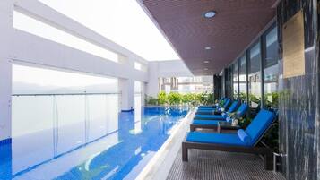 Utomhuspool, solstolar och livvakter på plats