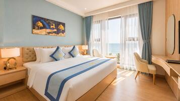 Habitació d'hotel amb llit, escriptori, cadira i un quadre a la paret.