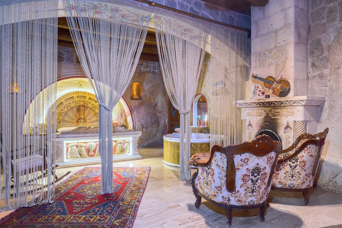 A room with a large ornate mirror, a violin, and a fireplace.