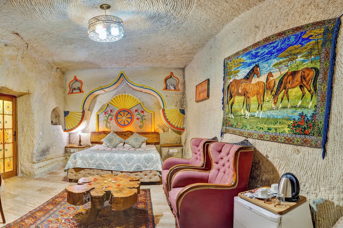 A traditional room with a bed, a desk, a chair, and a coffee table.