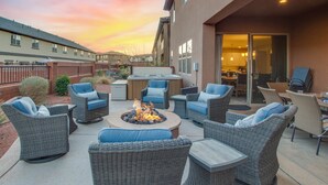 A patio area with wicker furniture, a fire pit, and a view of the building's interior. - Paradise Village Resort 103: Resort View, Private Hot Tub, Short Walking distance to Resort (Santa Clara)