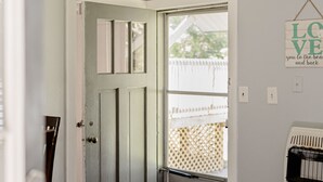 A hallway with a grey door, a ceiling fan, and a sign that reads "LAKEHOUSE".