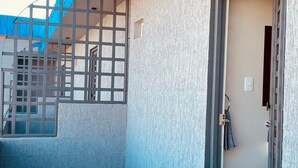 A building with a blue exterior, a tiled floor, and a door with a towel hanging on it. - Hotel Santa Cruz Residencial (San Luis Rio Colorado)