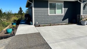 A residential house with a grey exterior, a front porch, and a driveway. - Cozy studio located near  Marina, hiking trails & downtown Sequim. Pet friendly. (Sequim)