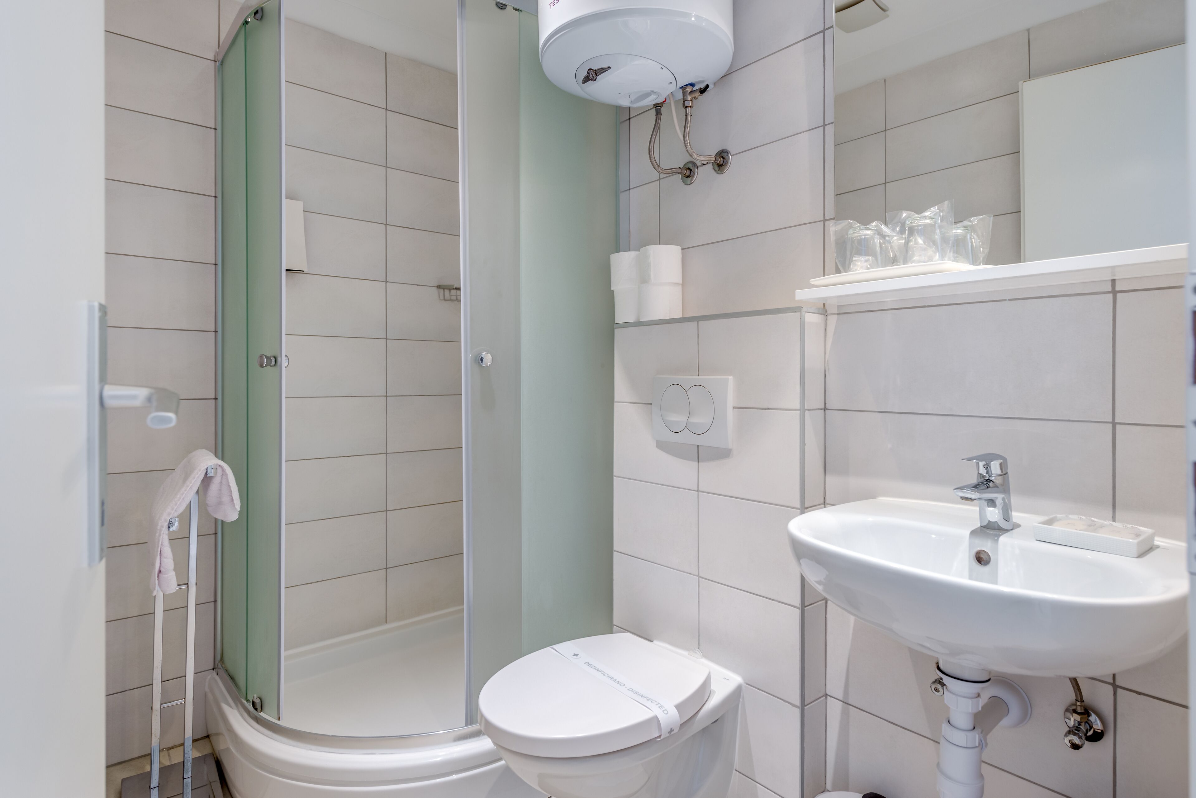 A modern bathroom with a shower, toilet, and sink.