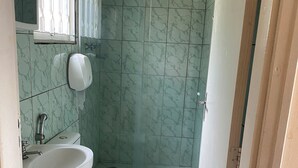 A bathroom with a sink, toilet, and shower. - Vale Das Aguas Thermas Park (Piracicaba)