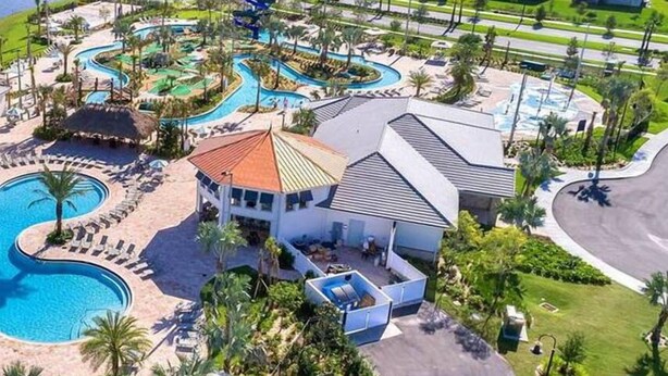 Un resort con piscina, parco acquatico e un edificio con tetto rosso.