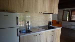 Una cocina moderna con armarios de madera, un lavamanos integrado y una cafetera.