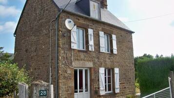 Traditional architecture with a symmetrical facade, satellite TV and lush surroundings.